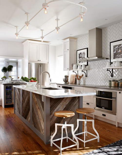 This rustic kitchen island is made of reclaimed barn wood. It has a white quartz countertop and a sink built into the island. The pearl like tiles have a small shine but not one to distract from the island.