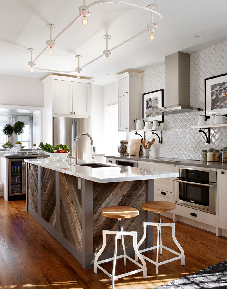Elegant kitchen photo in Toronto with a double-bowl sink, shaker cabinets, white cabinets, white backsplash, subway tile backsplash and stainless steel appliances