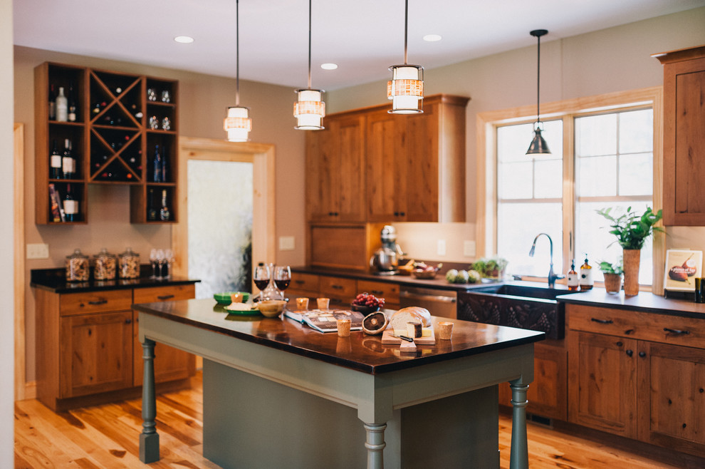 Inspiration for a large transitional u-shaped medium tone wood floor eat-in kitchen remodel in Boston with an island, shaker cabinets, medium tone wood cabinets, soapstone countertops, metallic backsplash, ceramic backsplash, stainless steel appliances and a farmhouse sink
