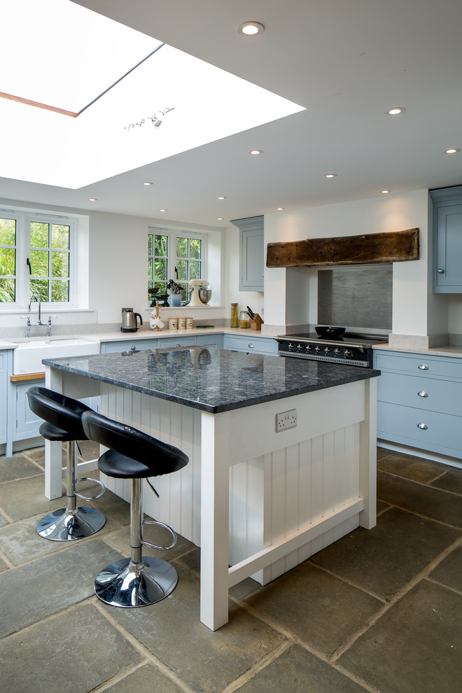 Foto på ett stort lantligt kök, med skåp i shakerstil, blå skåp, granitbänkskiva, grått stänkskydd, stänkskydd i metallkakel, rostfria vitvaror, en köksö och en rustik diskho