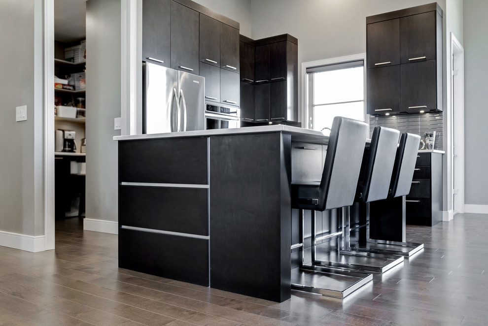 Inspiration for a contemporary kitchen in Calgary with a submerged sink, dark wood cabinets, grey splashback, stainless steel appliances and an island.