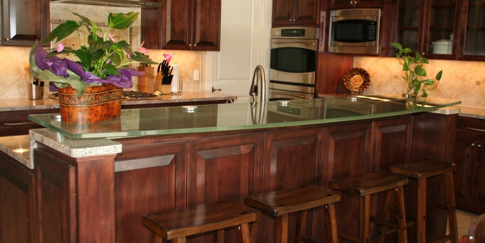 Kitchen - traditional kitchen idea in Austin with glass countertops and an island