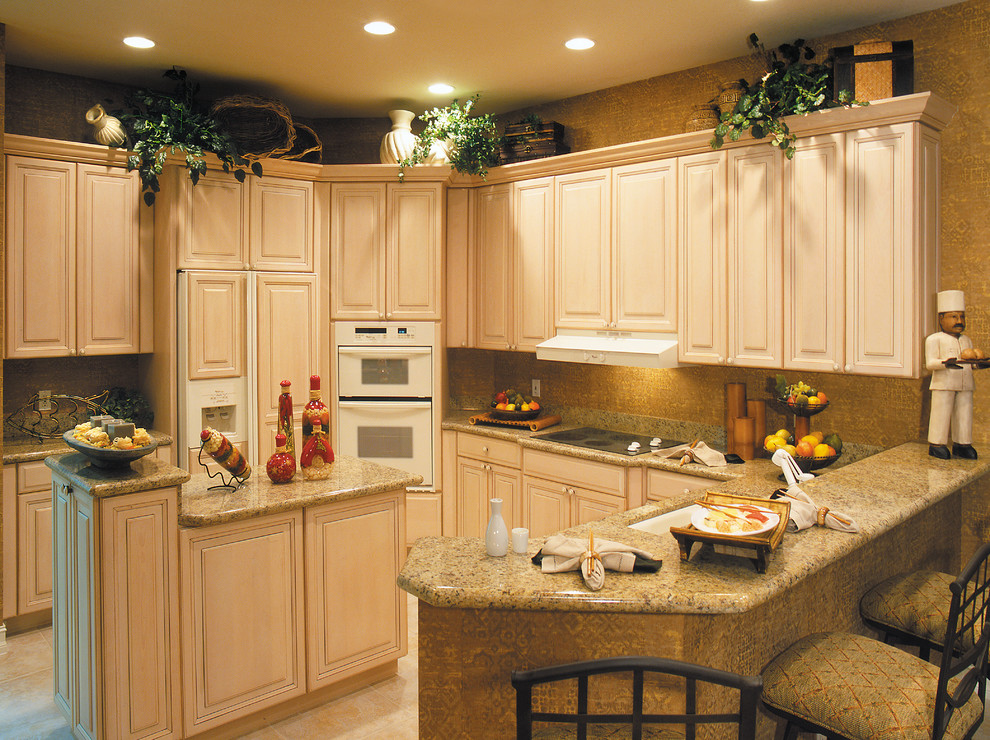 Bild på ett stort medelhavsstil kök, med en undermonterad diskho, luckor med upphöjd panel, skåp i ljust trä, granitbänkskiva, beige stänkskydd, integrerade vitvaror, klinkergolv i keramik och en köksö