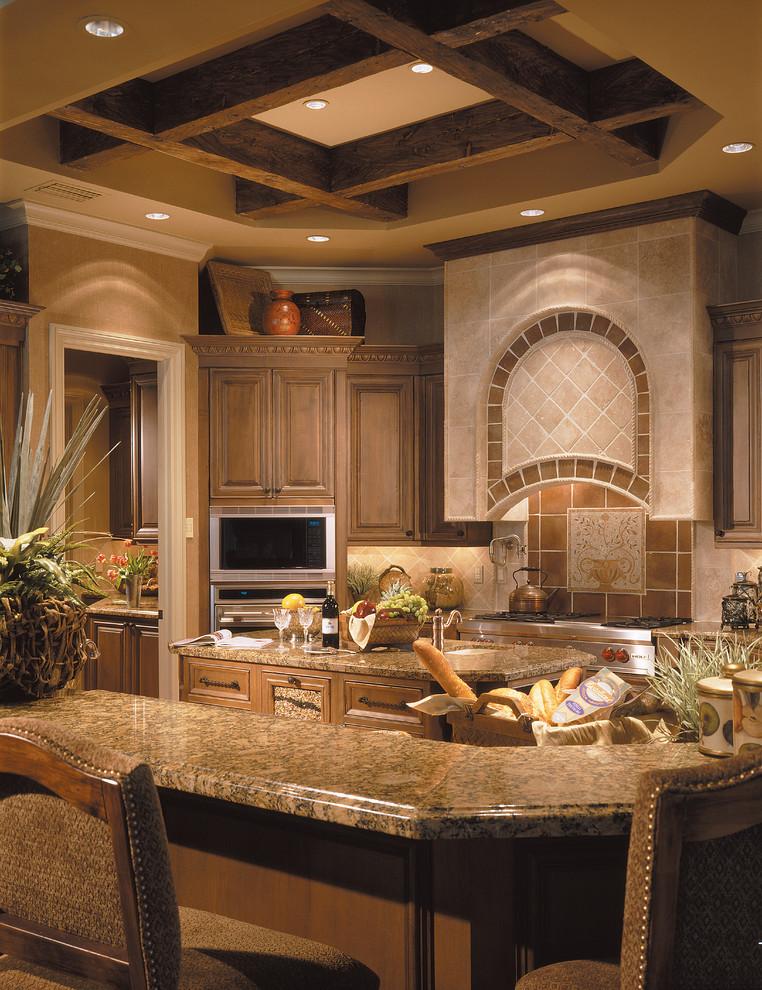 Large tuscan u-shaped ceramic tile open concept kitchen photo in Miami with an undermount sink, raised-panel cabinets, dark wood cabinets, granite countertops, beige backsplash, stone tile backsplash, stainless steel appliances and an island