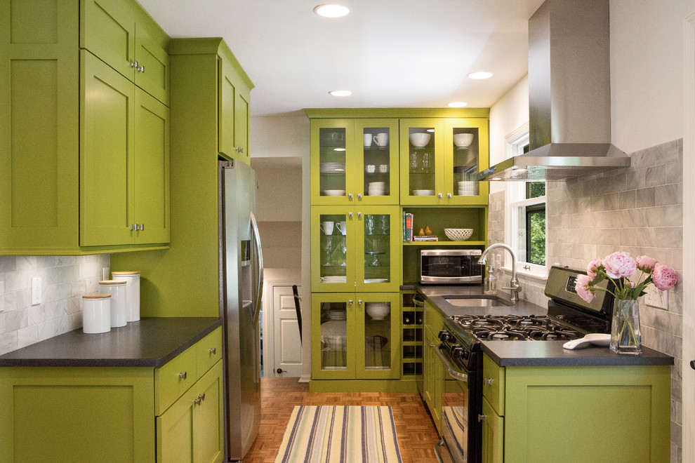 Foto på ett litet 60 tals kök, med en undermonterad diskho, skåp i shakerstil, gröna skåp, laminatbänkskiva, vitt stänkskydd, stänkskydd i stenkakel, rostfria vitvaror och mellanmörkt trägolv