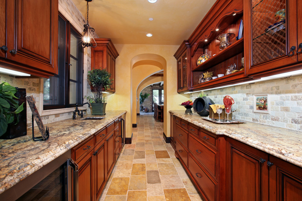 Inspiration for a mediterranean galley kitchen pantry remodel in Orange County with an undermount sink, raised-panel cabinets, medium tone wood cabinets, granite countertops, beige backsplash, stainless steel appliances and no island