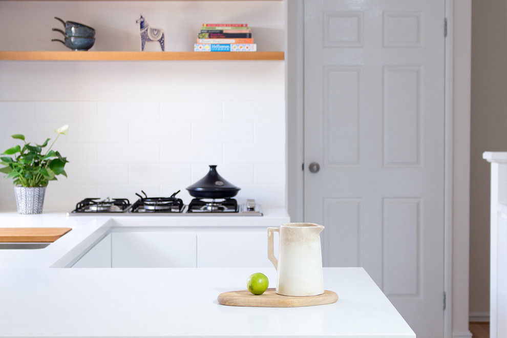 На фото: маленькая п-образная кухня в скандинавском стиле с обеденным столом, столешницей из кварцевого агломерата, белым фартуком и белой столешницей для на участке и в саду с