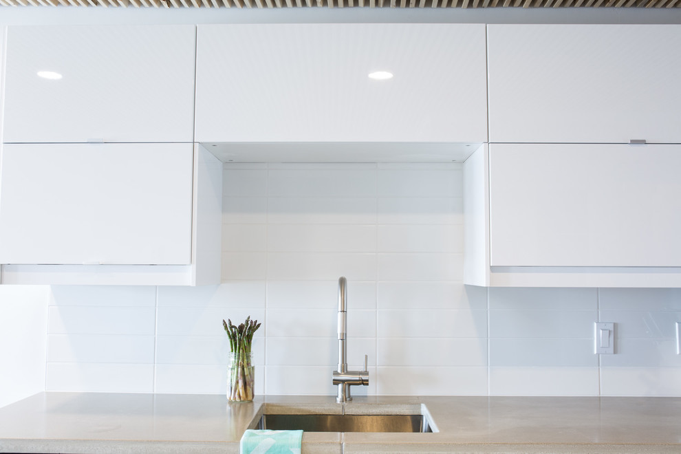 Small scandi kitchen in Other with flat-panel cabinets, white cabinets, concrete worktops, white splashback and ceramic splashback.