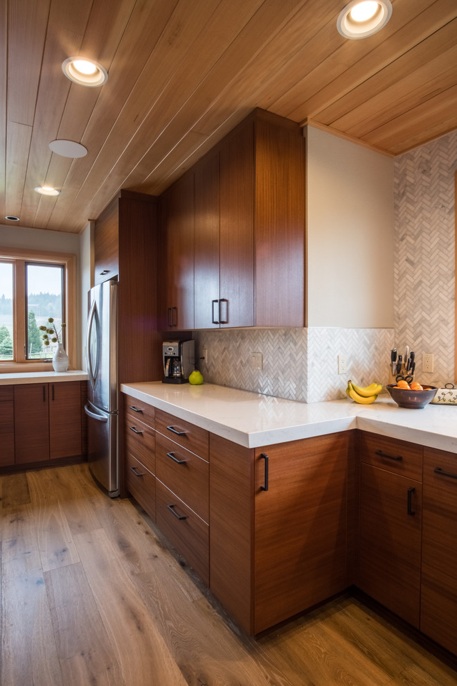 Idéer för att renovera ett mycket stort funkis vit linjärt vitt kök och matrum, med en undermonterad diskho, släta luckor, skåp i mellenmörkt trä, bänkskiva i kvarts, grått stänkskydd, stänkskydd i stenkakel, rostfria vitvaror, en köksö och brunt golv