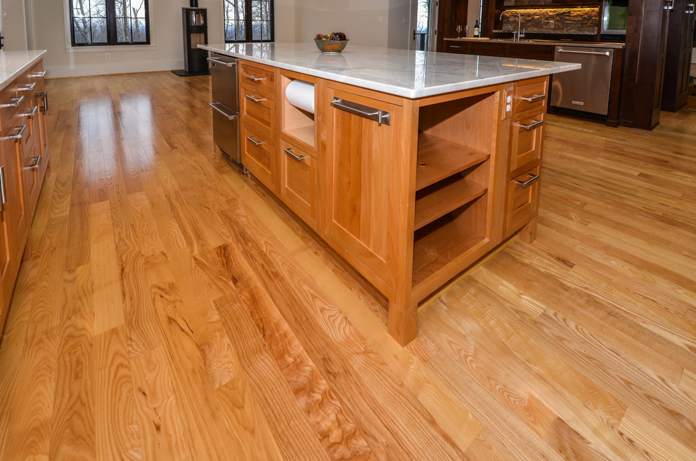 ワシントンD.C.にある高級な巨大な北欧スタイルのおしゃれなキッチン (シェーカースタイル扉のキャビネット、中間色木目調キャビネット、シルバーの調理設備、無垢フローリング、茶色い床) の写真