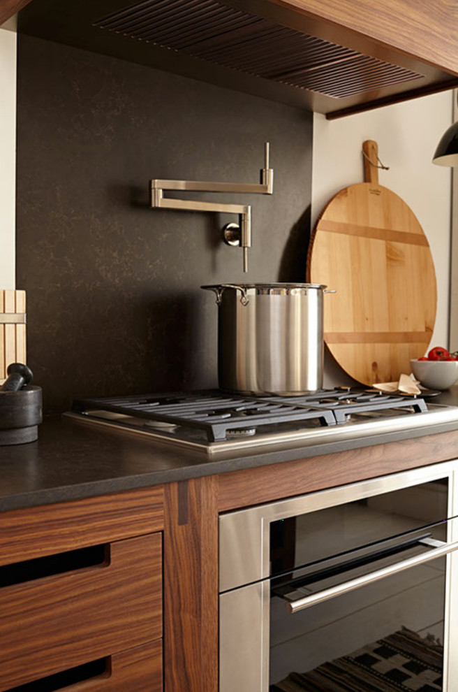 Modern inredning av ett mellanstort kök och matrum, med en rustik diskho, släta luckor, skåp i mellenmörkt trä, bänkskiva i kvarts, brunt stänkskydd, stänkskydd i sten, rostfria vitvaror och en köksö