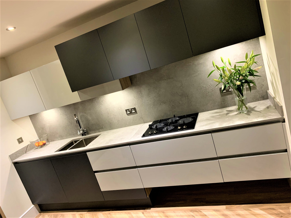 Foto di una piccola cucina nordica con lavello a doppia vasca, ante lisce, ante in legno chiaro, top in cemento, elettrodomestici neri e pavimento in vinile