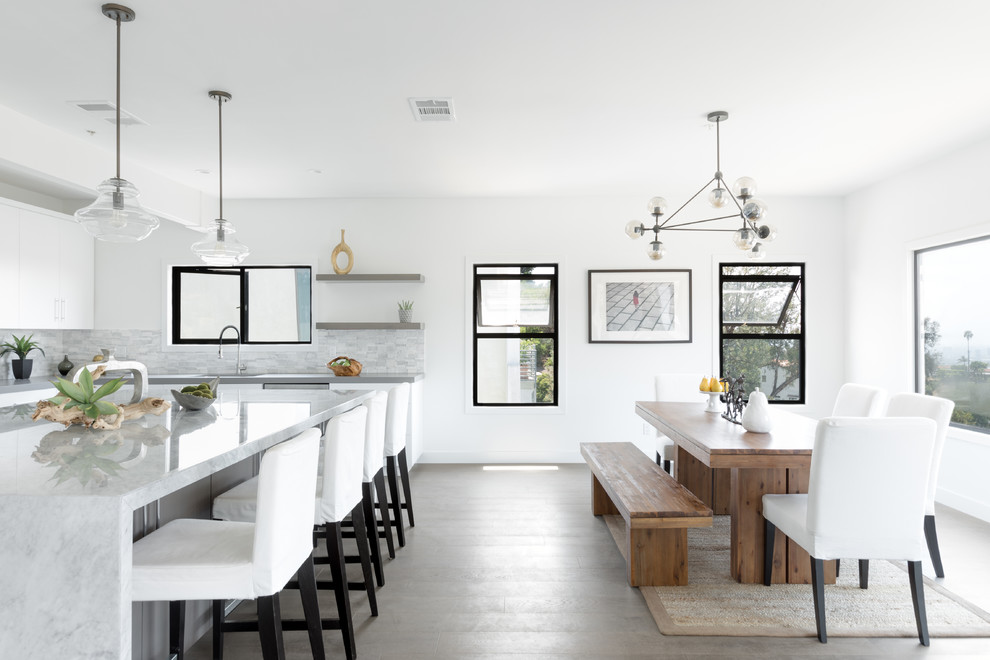 This is an example of a scandi u-shaped kitchen/diner in Los Angeles with grey splashback and an island.