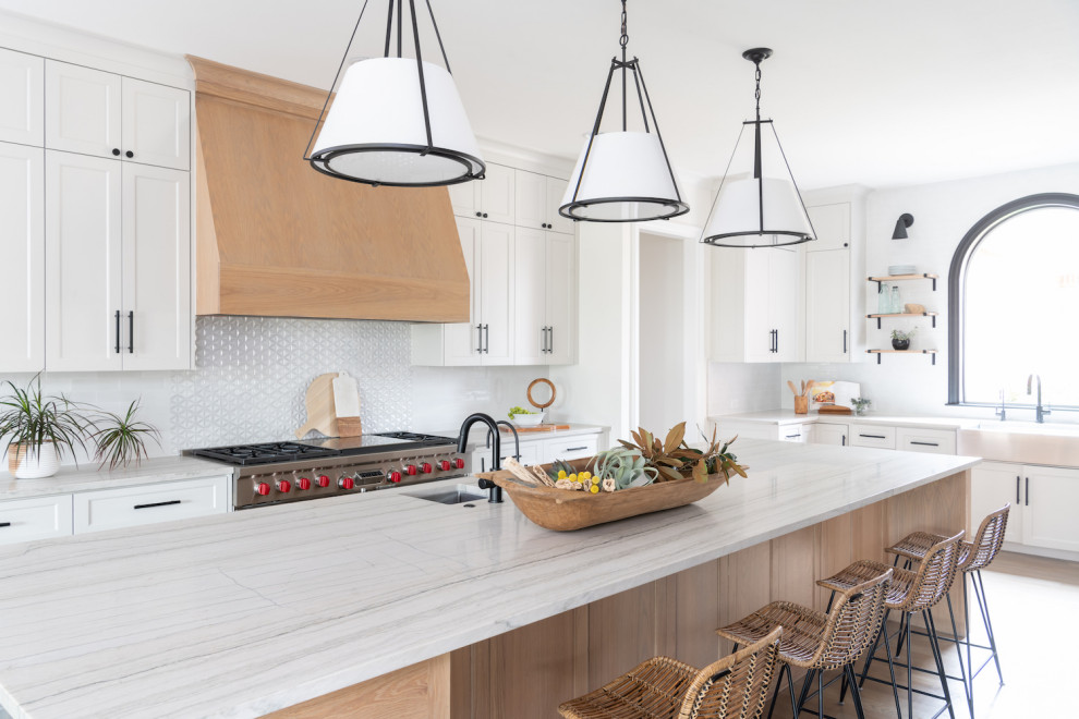 Foto på ett stort funkis kök, med en undermonterad diskho, rostfria vitvaror och en köksö
