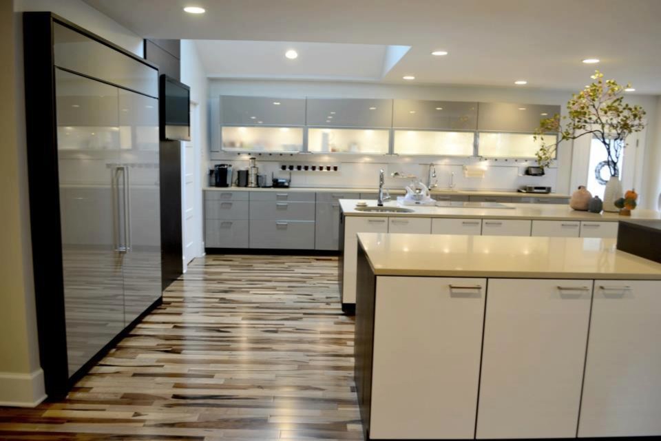 Exempel på ett stort modernt kök och matrum, med en undermonterad diskho, luckor med lamellpanel, vita skåp, bänkskiva i kvartsit, grått stänkskydd, stänkskydd i metallkakel, integrerade vitvaror, mellanmörkt trägolv och flera köksöar