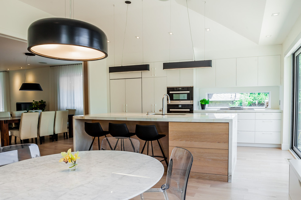 Immagine di una cucina scandinava di medie dimensioni con ante lisce, ante bianche e parquet chiaro