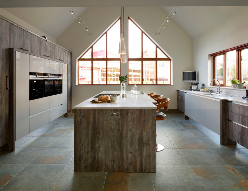 Foto di una grande cucina scandinava con lavello da incasso, ante lisce, ante bianche, top in quarzite, elettrodomestici da incasso, pavimento in gres porcellanato, pavimento grigio e top bianco