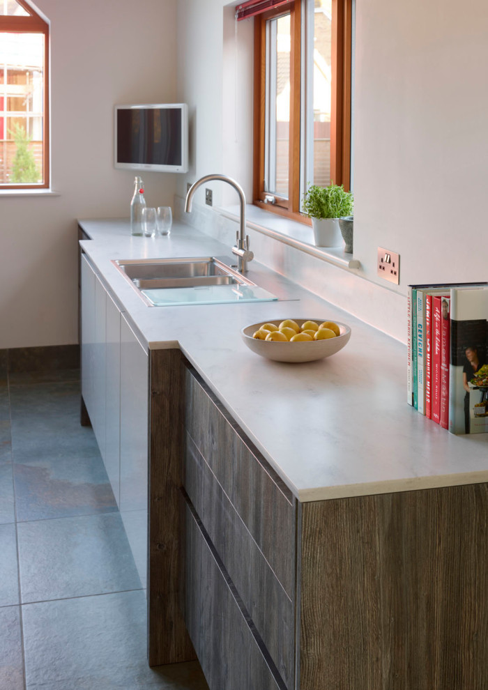 Immagine di una grande cucina nordica con lavello da incasso, ante lisce, ante bianche, top in quarzite, elettrodomestici da incasso, pavimento in gres porcellanato, pavimento grigio e top bianco