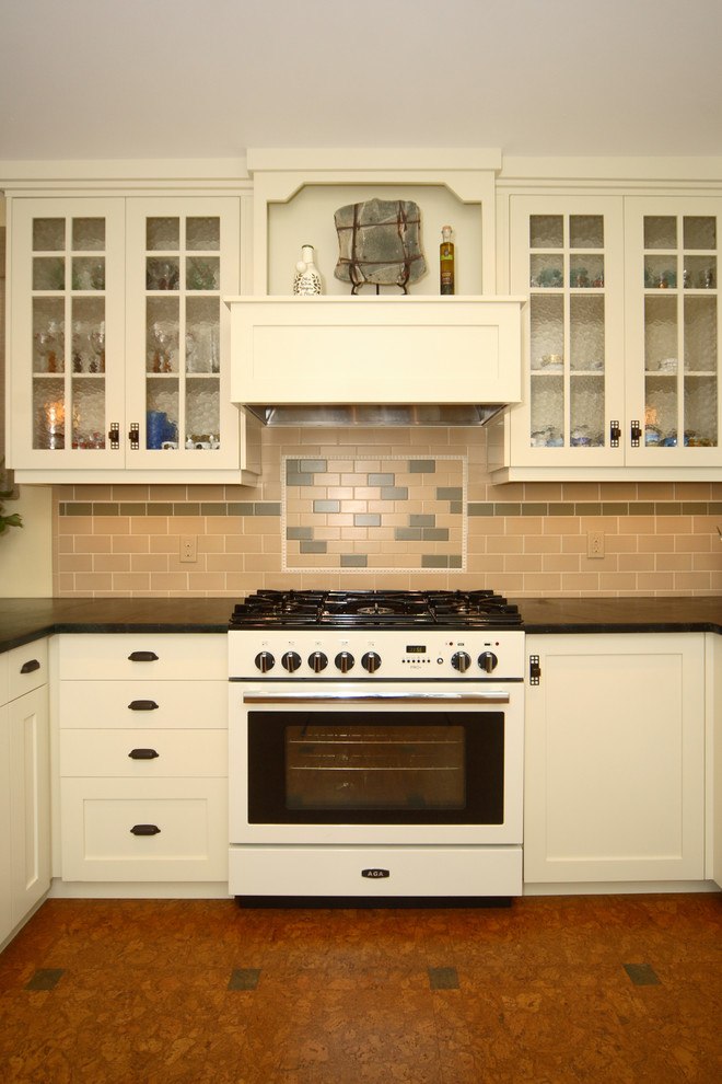 Bild på ett avskilt, mellanstort vintage u-kök, med en rustik diskho, skåp i shakerstil, beige skåp, granitbänkskiva, beige stänkskydd, stänkskydd i keramik, vita vitvaror, korkgolv och en halv köksö