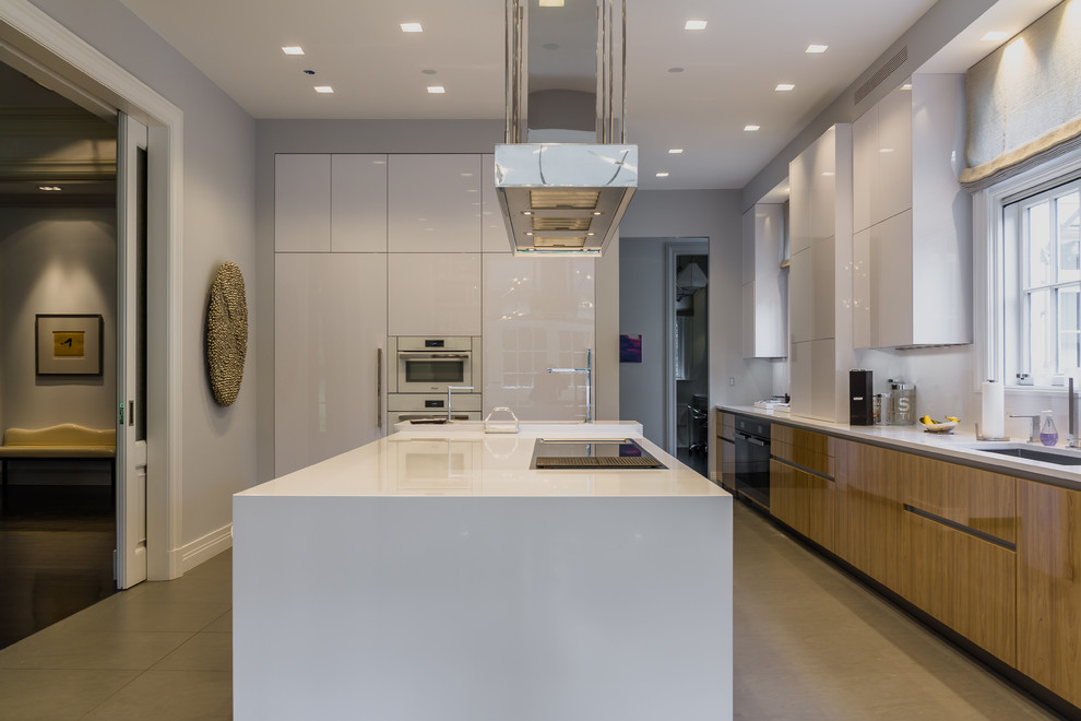 This is an example of a medium sized modern l-shaped kitchen/diner in New York with a submerged sink, flat-panel cabinets, white cabinets, engineered stone countertops, white splashback, stainless steel appliances, ceramic flooring and an island.