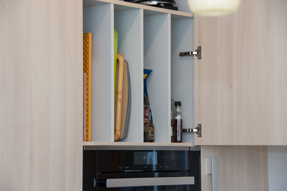 Foto di una piccola cucina moderna con lavello sottopiano, ante lisce, ante in legno chiaro, top in quarzo composito, paraspruzzi multicolore, paraspruzzi con piastrelle di vetro e elettrodomestici in acciaio inossidabile