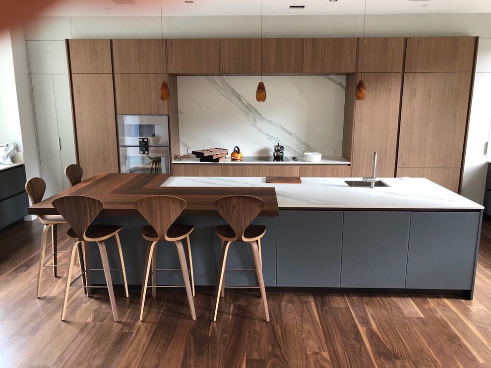 Exempel på ett mycket stort modernt flerfärgad flerfärgat l-kök, med en undermonterad diskho, släta luckor, blå skåp, bänkskiva i kvarts, flerfärgad stänkskydd, stänkskydd i sten, färgglada vitvaror, mellanmörkt trägolv, en köksö och brunt golv