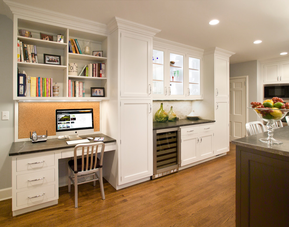 Example of a large transitional u-shaped medium tone wood floor and brown floor enclosed kitchen design in New York with shaker cabinets, white cabinets, an undermount sink, white backsplash, marble backsplash, stainless steel appliances, an island, granite countertops and black countertops