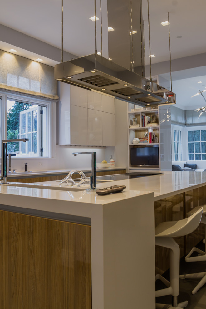 Inspiration for a mid-sized modern l-shaped ceramic tile eat-in kitchen remodel in New York with an undermount sink, flat-panel cabinets, white cabinets, quartz countertops, white backsplash, stainless steel appliances and an island