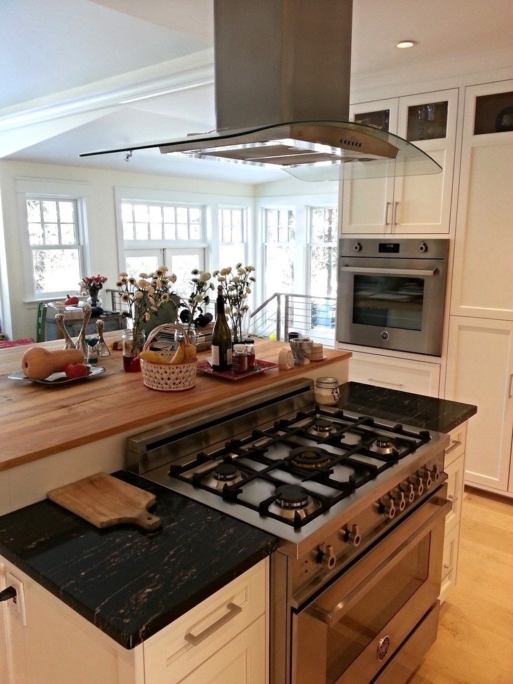 Eat-in kitchen - mid-sized traditional u-shaped light wood floor eat-in kitchen idea in New York with an undermount sink, recessed-panel cabinets, white cabinets, granite countertops, stainless steel appliances and an island