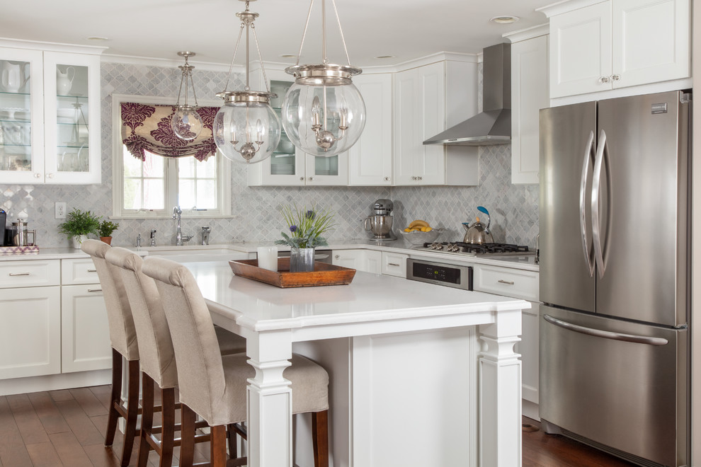 Bild på ett stort vintage vit vitt l-kök, med en rustik diskho, luckor med infälld panel, vita skåp, granitbänkskiva, grått stänkskydd, stänkskydd i marmor, rostfria vitvaror, bambugolv, en köksö och brunt golv