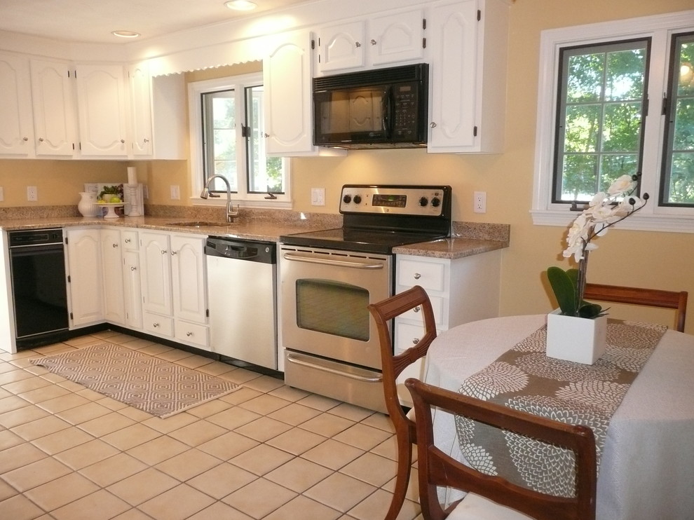 Example of a mid-sized transitional l-shaped beige floor eat-in kitchen design in Boston with an undermount sink, raised-panel cabinets, white cabinets, granite countertops, stainless steel appliances, no island and beige countertops