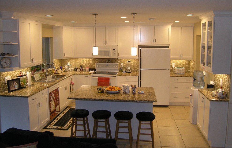 Inredning av ett klassiskt mellanstort kök, med en dubbel diskho, skåp i shakerstil, vita skåp, granitbänkskiva, grönt stänkskydd, stänkskydd i stickkakel, rostfria vitvaror, klinkergolv i keramik och en köksö