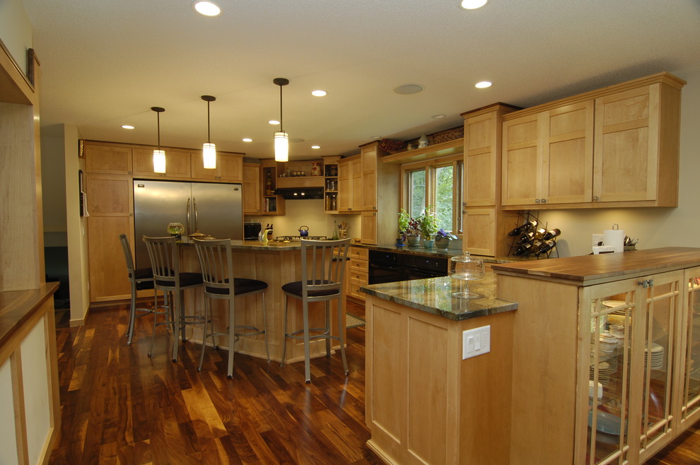 Klassische Küchenbar mit Glasfronten, Küchengeräten aus Edelstahl, hellbraunen Holzschränken, Granit-Arbeitsplatte und braunem Boden in Minneapolis