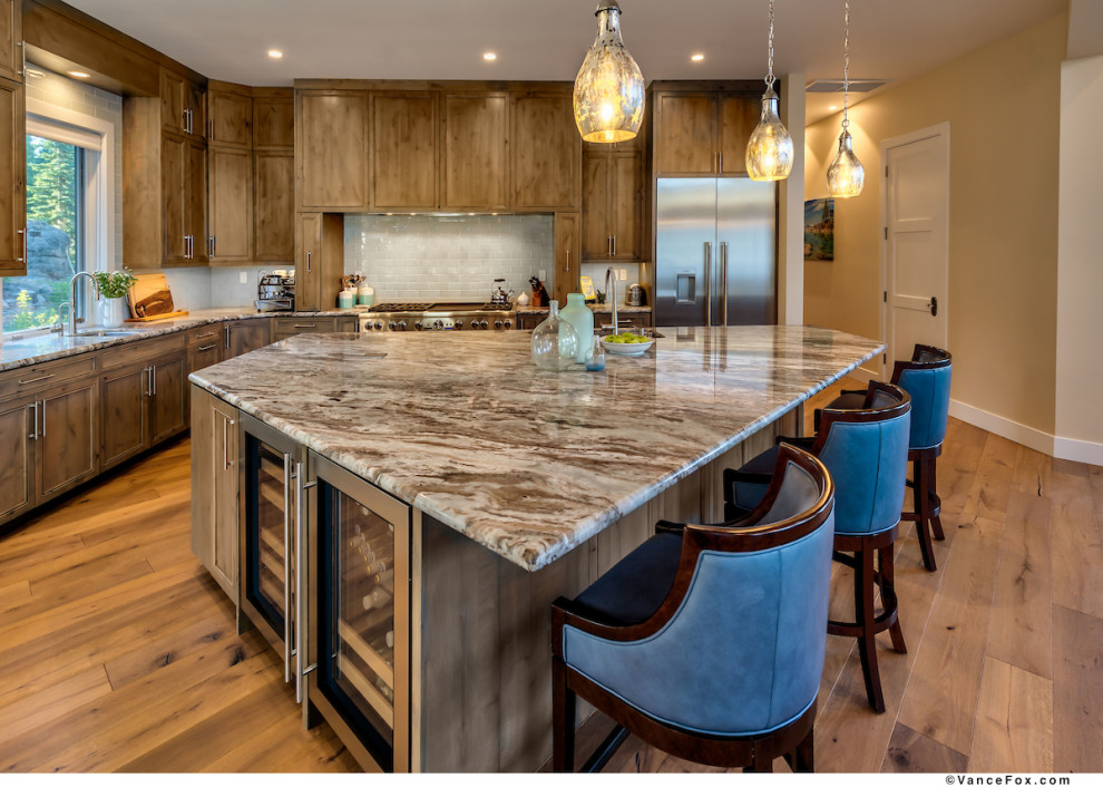 Cette photo montre une cuisine ouverte chic en bois clair de taille moyenne avec un plan de travail en granite, une crédence blanche, une crédence en céramique, un électroménager en acier inoxydable et îlot.