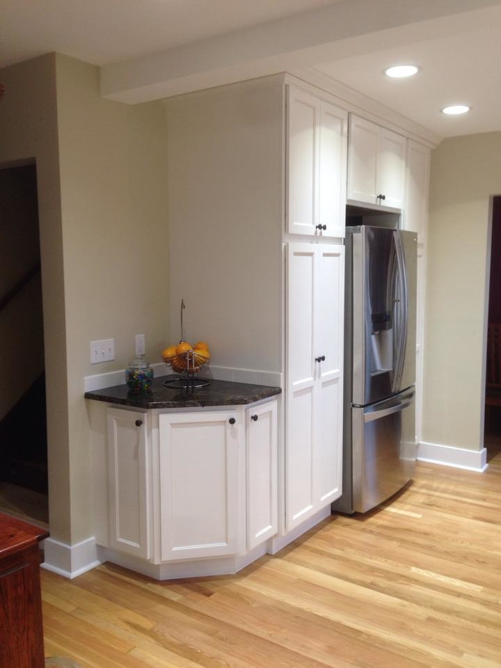 Photo of a large traditional u-shaped kitchen pantry in Seattle with a submerged sink, shaker cabinets, white cabinets, granite worktops, white splashback, metro tiled splashback, stainless steel appliances, medium hardwood flooring and no island.