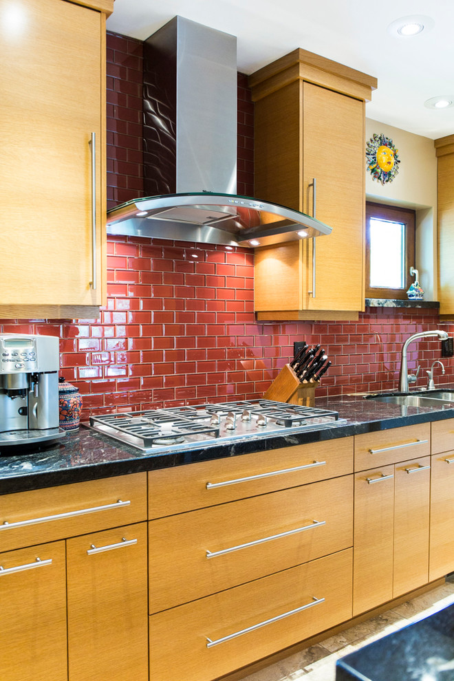 Idee per una grande cucina design con ante in legno chiaro, paraspruzzi rosso, paraspruzzi con piastrelle di vetro e elettrodomestici in acciaio inossidabile