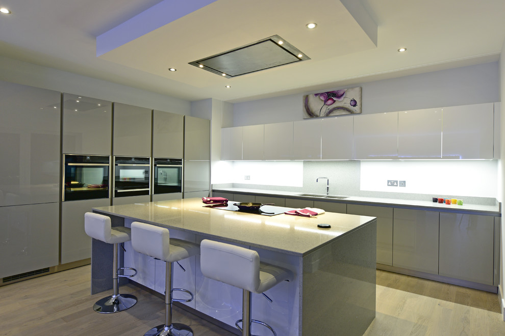 Design ideas for a large contemporary kitchen in London with quartz worktops and black appliances.