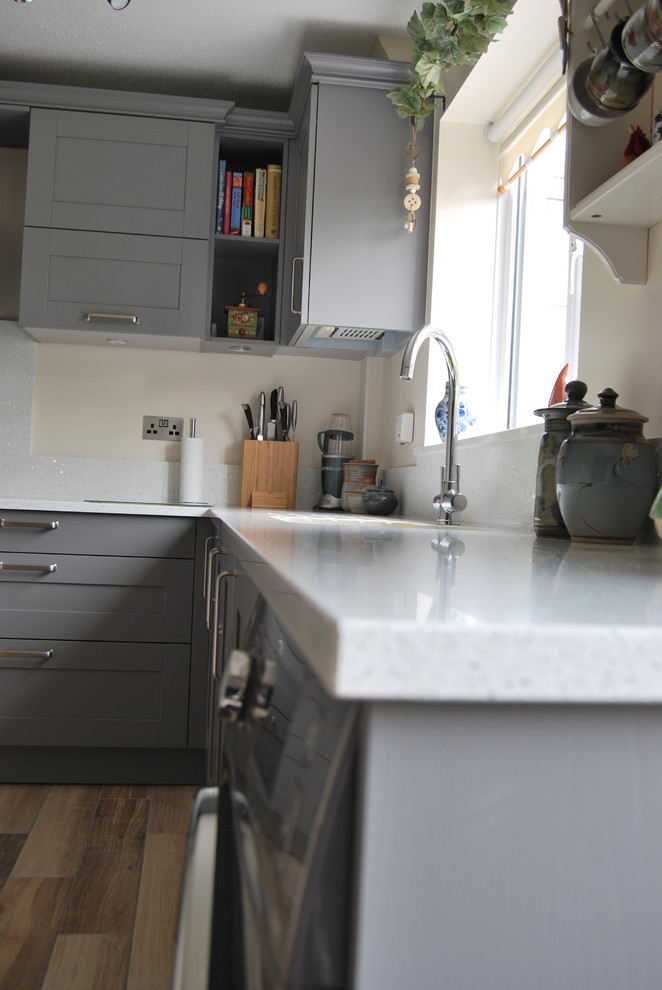 This is an example of a small traditional u-shaped kitchen/diner in Cheshire with grey cabinets, quartz worktops, no island, shaker cabinets, white splashback and stone slab splashback.