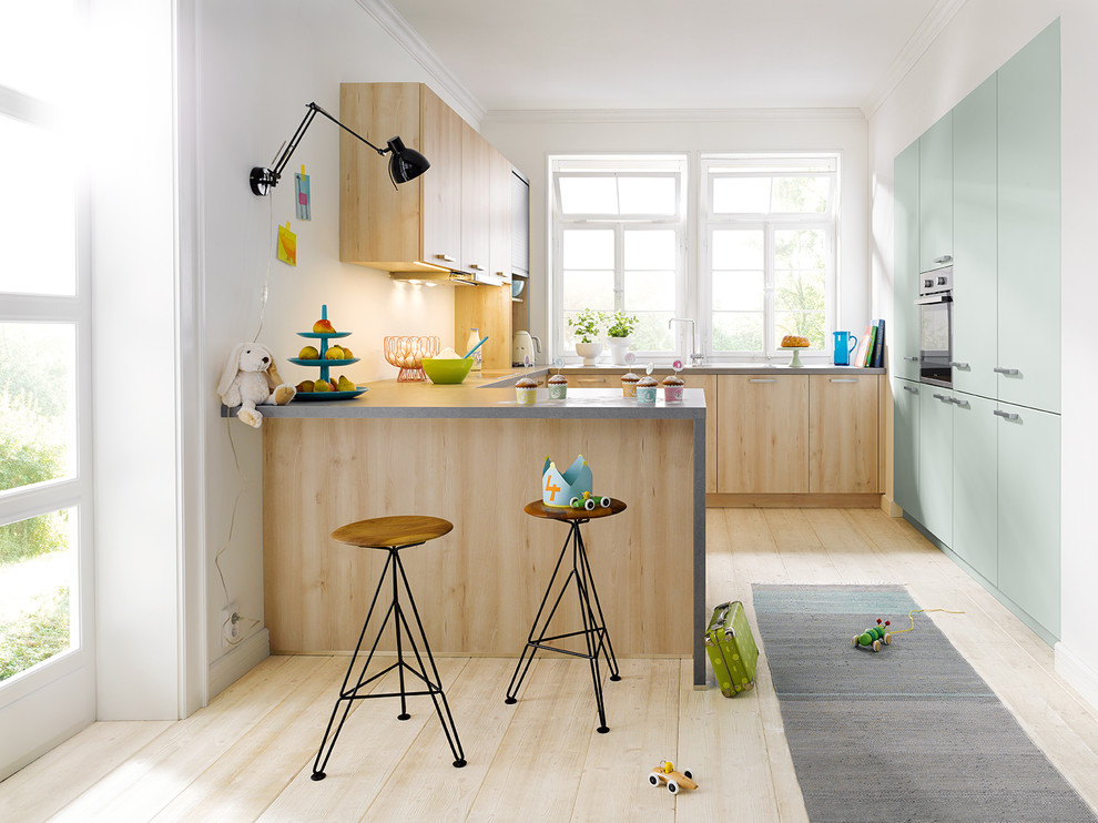 Photo of a contemporary u-shaped kitchen in Other with flat-panel cabinets, green cabinets, white splashback, integrated appliances, light hardwood flooring, a breakfast bar and beige floors.