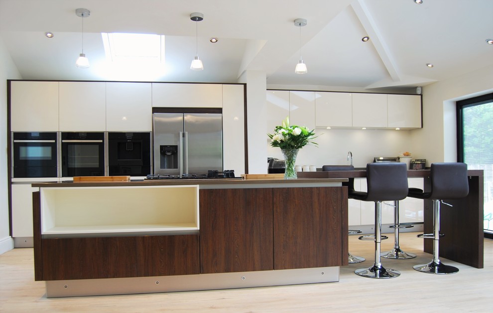 Example of a large trendy single-wall open concept kitchen design in Manchester with an island, flat-panel cabinets, dark wood cabinets and quartzite countertops