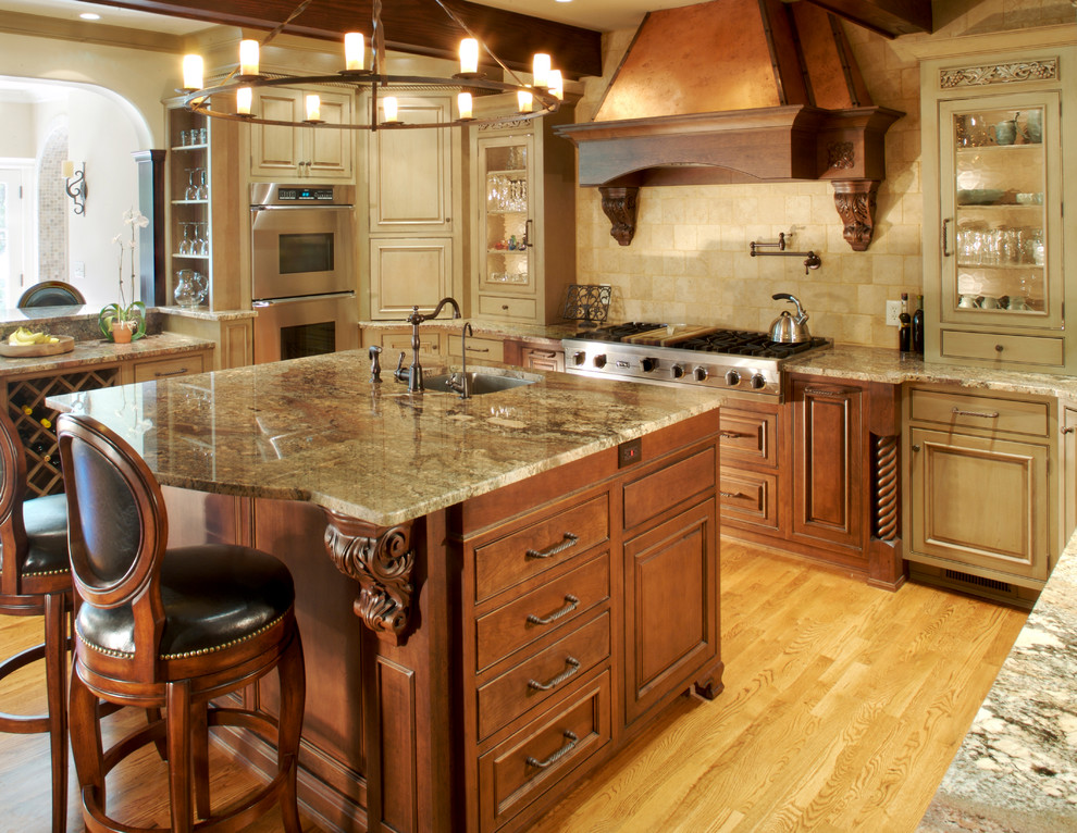 Enclosed kitchen - large traditional u-shaped light wood floor and brown floor enclosed kitchen idea in Atlanta with an undermount sink, beaded inset cabinets, dark wood cabinets, granite countertops, beige backsplash, limestone backsplash, paneled appliances and an island