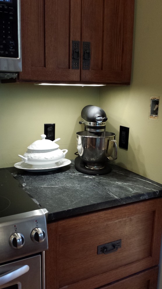 Immagine di una cucina american style con lavello a doppia vasca, ante in stile shaker, ante in legno scuro, top in saponaria e elettrodomestici in acciaio inossidabile