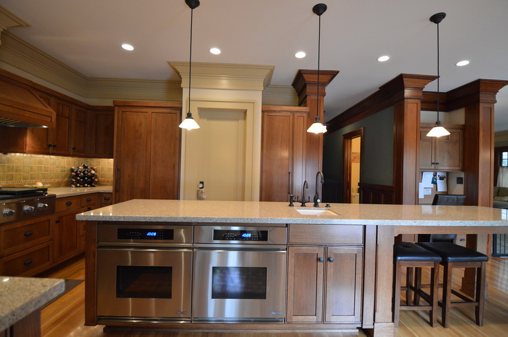 Foto di una cucina stile americano con lavello sottopiano, ante con riquadro incassato, ante in legno chiaro, paraspruzzi beige, elettrodomestici in acciaio inossidabile e parquet chiaro