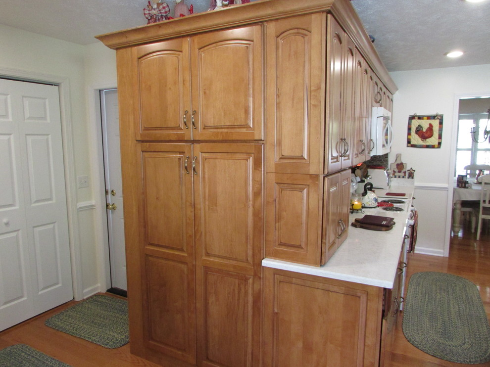 Bild på ett mellanstort lantligt kök, med en rustik diskho, luckor med upphöjd panel, skåp i mellenmörkt trä, bänkskiva i kvarts, flerfärgad stänkskydd, stänkskydd i skiffer, vita vitvaror, mellanmörkt trägolv och en köksö