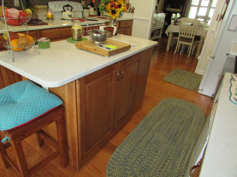 Exempel på ett mellanstort lantligt kök, med en rustik diskho, luckor med upphöjd panel, skåp i mellenmörkt trä, bänkskiva i kvarts, flerfärgad stänkskydd, stänkskydd i skiffer, vita vitvaror, mellanmörkt trägolv och en köksö
