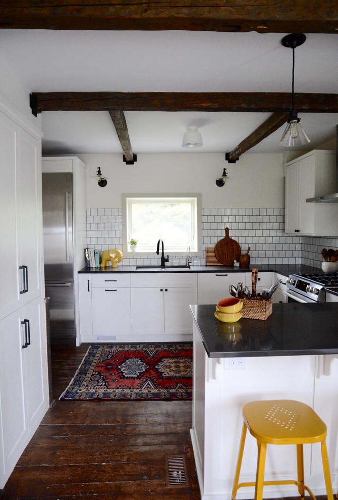 Inspiration for a small scandinavian u-shaped dark wood floor eat-in kitchen remodel in Other with an undermount sink, shaker cabinets, white cabinets, quartz countertops, white backsplash, ceramic backsplash, stainless steel appliances and a peninsula