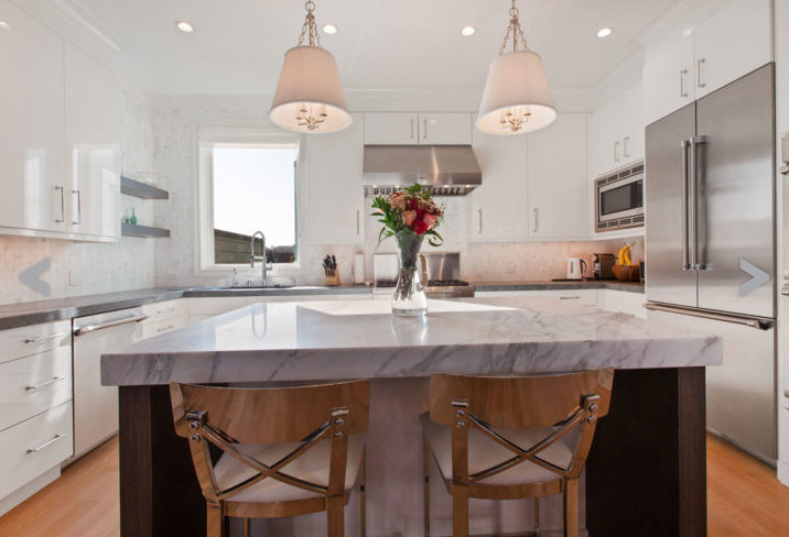 This is an example of a medium sized classic u-shaped kitchen in San Francisco with a submerged sink, flat-panel cabinets, white cabinets, marble worktops, stainless steel appliances, light hardwood flooring, an island and beige floors.