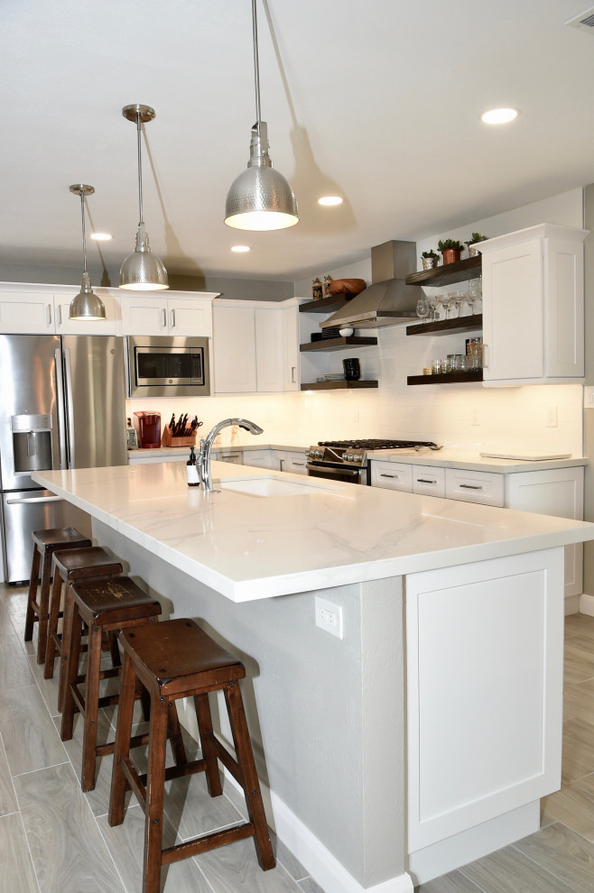 Exempel på ett mellanstort klassiskt vit vitt kök, med en undermonterad diskho, skåp i shakerstil, vita skåp, bänkskiva i kvarts, vitt stänkskydd, stänkskydd i tunnelbanekakel, rostfria vitvaror, klinkergolv i porslin, en köksö och flerfärgat golv