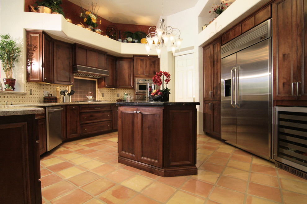 Inspiration for a timeless terra-cotta tile open concept kitchen remodel in Phoenix with recessed-panel cabinets, dark wood cabinets, marble countertops, beige backsplash, ceramic backsplash, stainless steel appliances and an island
