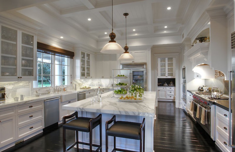 Eat-in kitchen - large traditional u-shaped dark wood floor and brown floor eat-in kitchen idea in Phoenix with an undermount sink, recessed-panel cabinets, white cabinets, marble countertops, white backsplash, stone slab backsplash, stainless steel appliances and an island